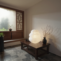 Light fixture on a wooden table in a room with a window and plants.